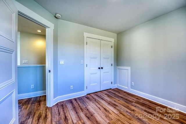 unfurnished bedroom featuring a closet and dark hardwood / wood-style flooring