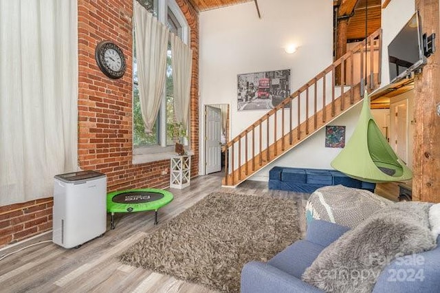 interior space with hardwood / wood-style flooring and brick wall