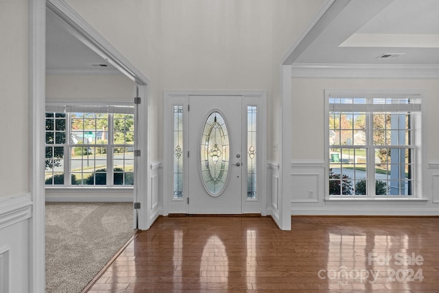 foyer entrance featuring ornamental molding, dark hardwood / wood-style floors, and a healthy amount of sunlight