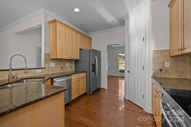 kitchen featuring sink, crown molding, dark hardwood / wood-style floors, dark stone countertops, and stainless steel appliances