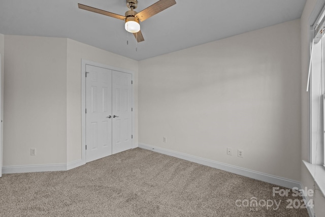 unfurnished bedroom featuring ceiling fan, a closet, and carpet