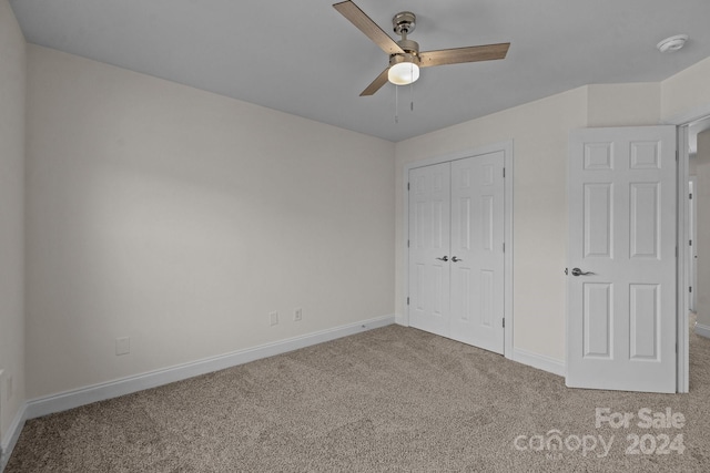 unfurnished bedroom with ceiling fan, a closet, and carpet floors