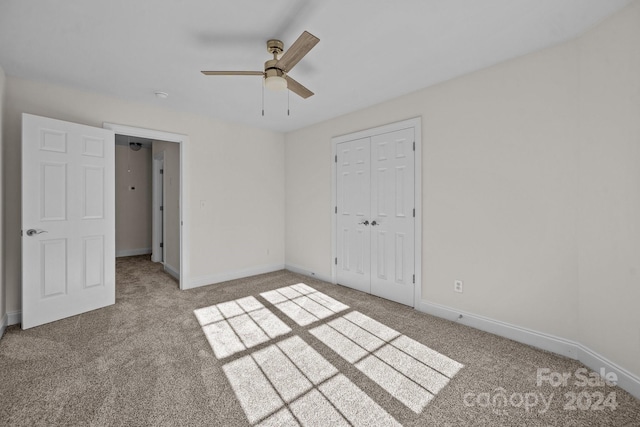 unfurnished bedroom with ceiling fan, a closet, and light carpet