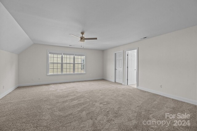 carpeted empty room with ceiling fan and vaulted ceiling