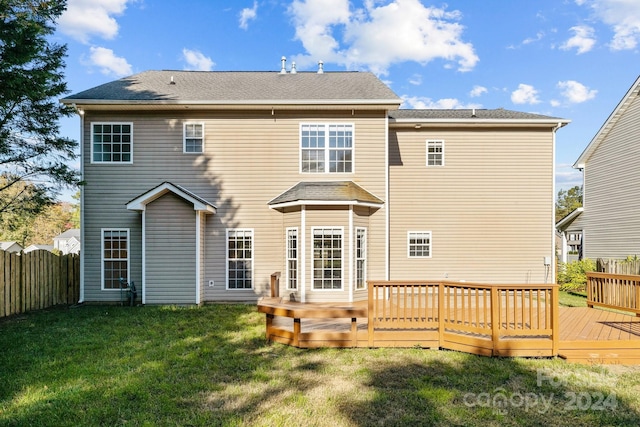 rear view of property featuring a lawn and a wooden deck