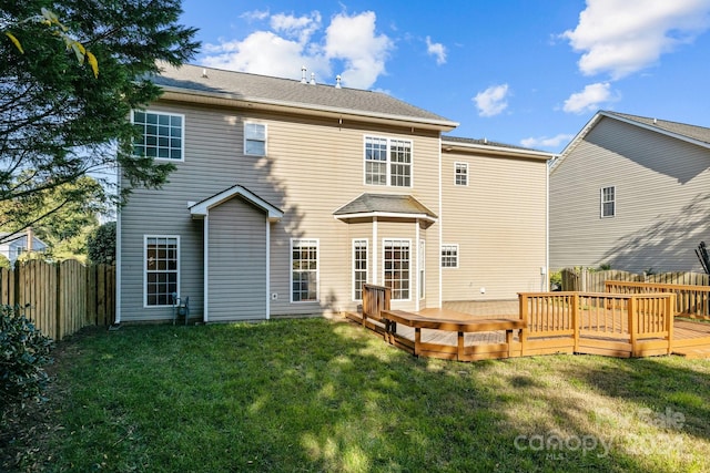 back of house featuring a yard and a deck