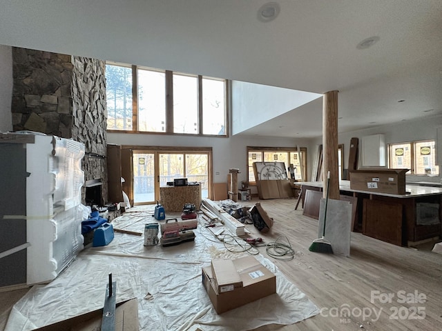 living room featuring a towering ceiling and light wood-type flooring