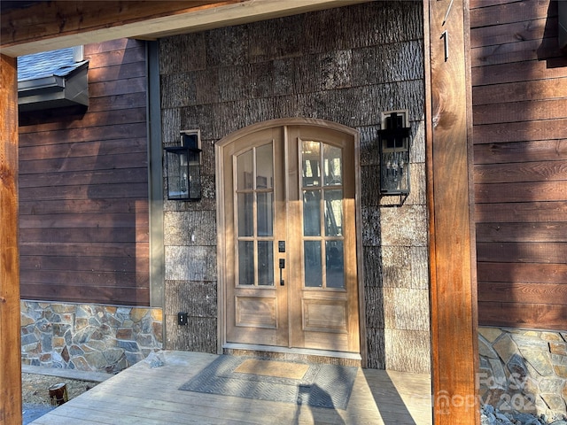 doorway to property featuring stone siding and french doors