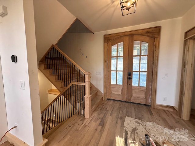 entryway with french doors, stairway, wood finished floors, and baseboards