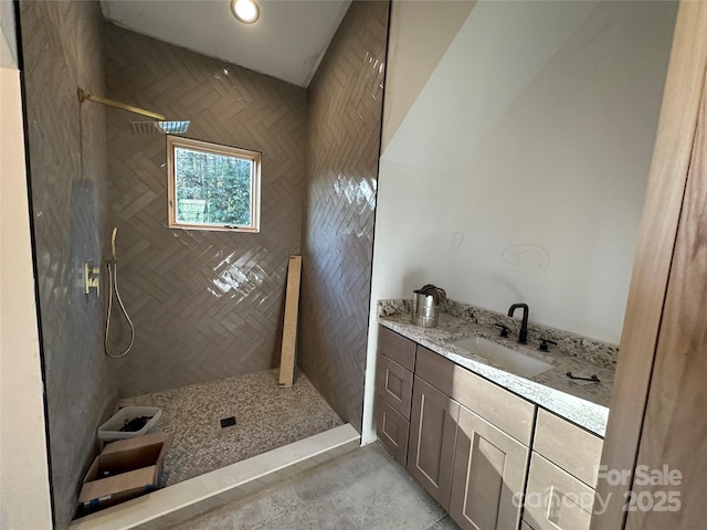 bathroom with recessed lighting, tiled shower, and vanity