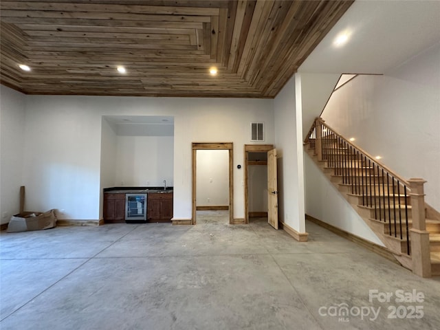 below grade area with beverage cooler, visible vents, baseboards, wood ceiling, and stairs