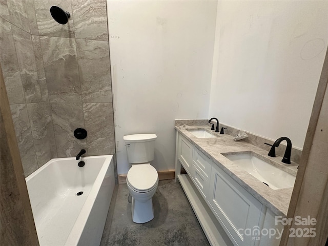 bathroom with concrete flooring, double vanity, a sink, and toilet