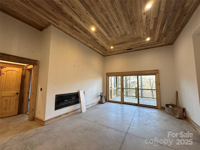 unfurnished living room featuring wooden ceiling, recessed lighting, a high ceiling, concrete floors, and a fireplace