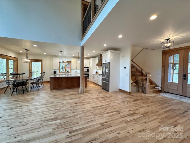 371 Hews Cir, Blowing Rock, NC 28605 - kitchen with appliances with stainless steel finishes, light wood-style floors, a chandelier, wall chimney exhaust hood, and open floor plan