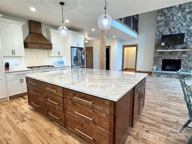 371 Hews Cir, Blowing Rock, NC 28605 - kitchen with stainless steel appliances, custom range hood, light wood-style flooring, white cabinetry, and recessed lighting