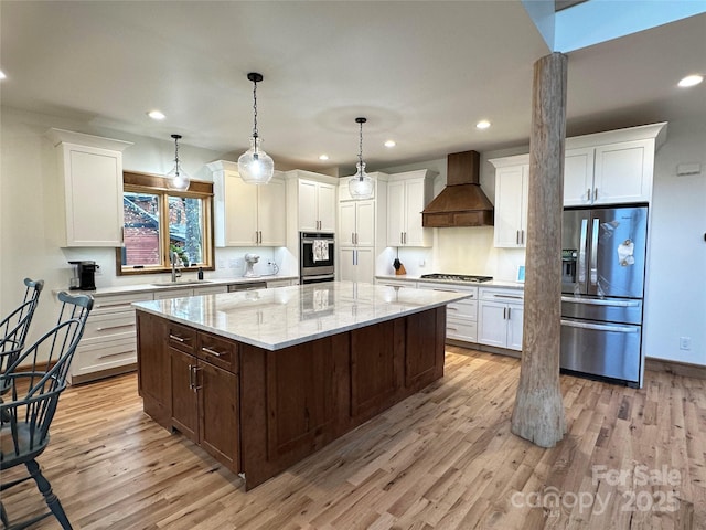 371 Hews Cir, Blowing Rock, NC 28605 - kitchen featuring stainless steel appliances, custom exhaust hood, a sink, light wood-style flooring, and a center island