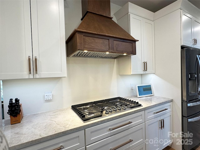 371 Hews Cir, Blowing Rock, NC 28605 - kitchen with stainless steel gas stovetop, premium range hood, fridge with ice dispenser, white cabinetry, and light stone counters