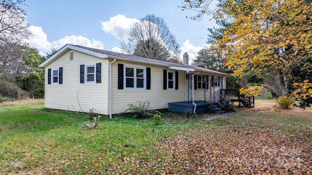 view of front of property with a front yard and a deck