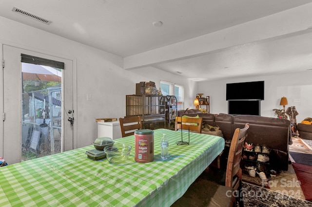 dining area featuring beam ceiling and a healthy amount of sunlight