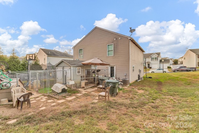 rear view of property with a yard, a patio area, and central AC unit