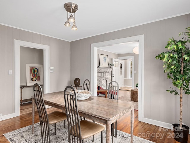 dining space with crown molding and hardwood / wood-style flooring