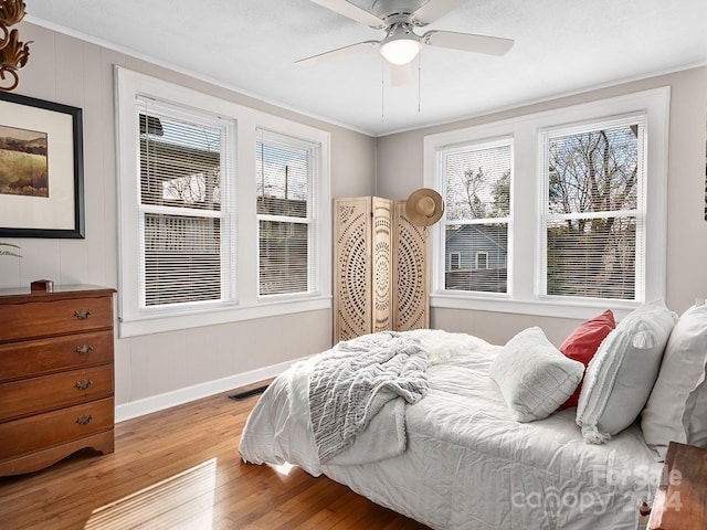 bedroom featuring hardwood / wood-style flooring, ceiling fan, and ornamental molding