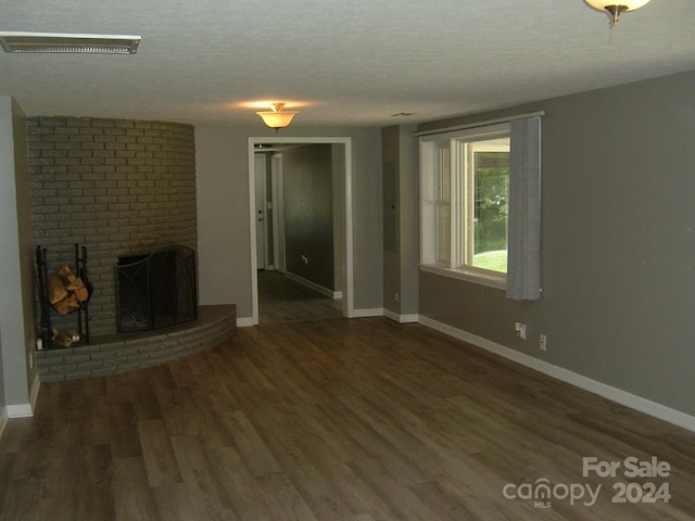 unfurnished living room with a textured ceiling, a fireplace, and dark wood-type flooring