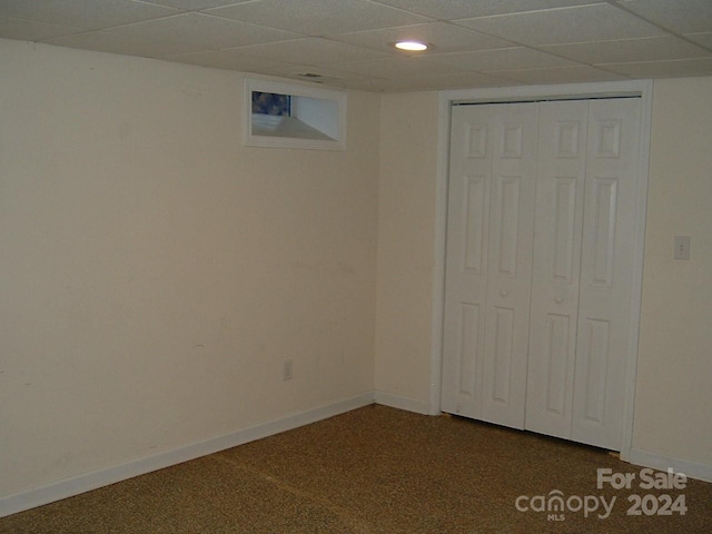 basement with carpet flooring and a drop ceiling