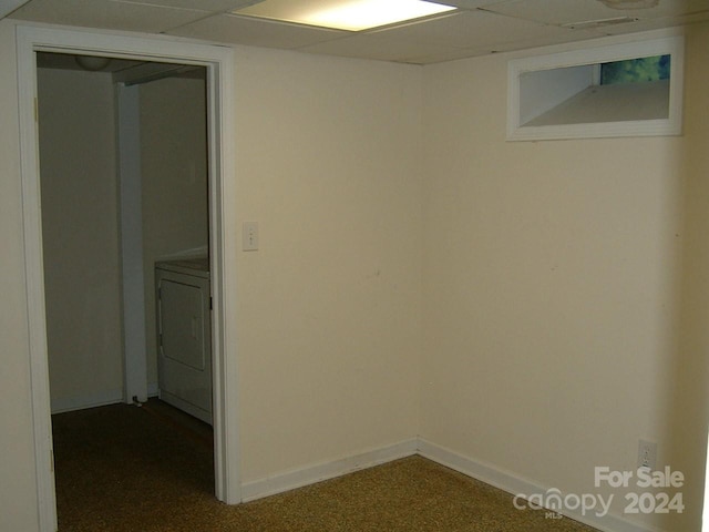 spare room featuring carpet, a drop ceiling, and washer / dryer