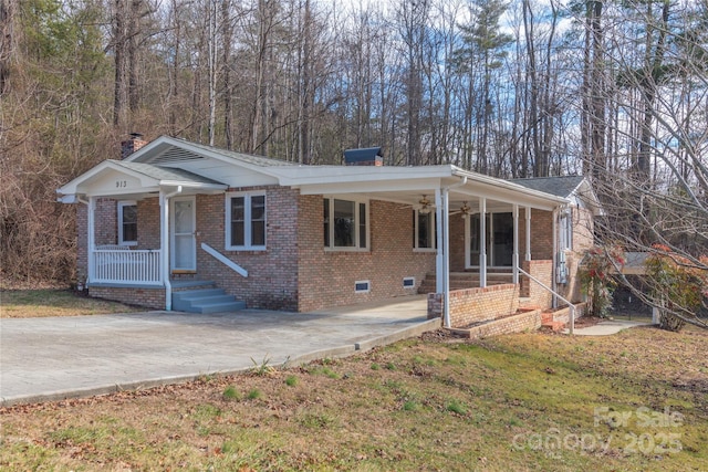 view of front of property with ceiling fan, covered porch, and a front lawn