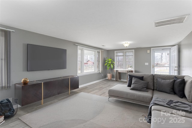 living room with light hardwood / wood-style floors and a wealth of natural light