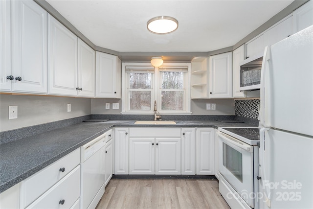 kitchen with white cabinetry, sink, white appliances, and light hardwood / wood-style flooring