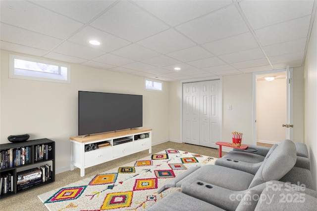 carpeted living room featuring a drop ceiling