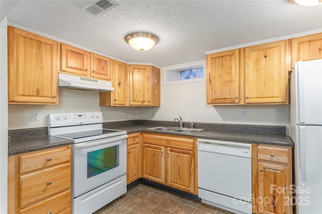 kitchen featuring sink, a textured ceiling, white appliances, and dark tile patterned flooring