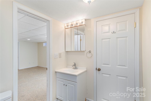 bathroom featuring vanity, a textured ceiling, and toilet