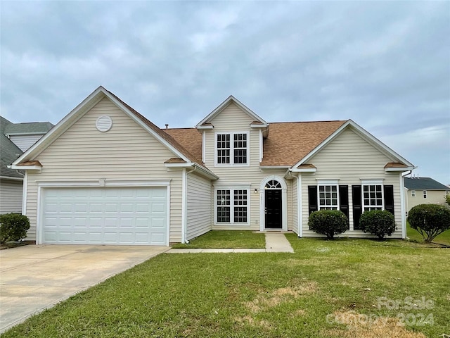 view of front property featuring a garage and a front lawn