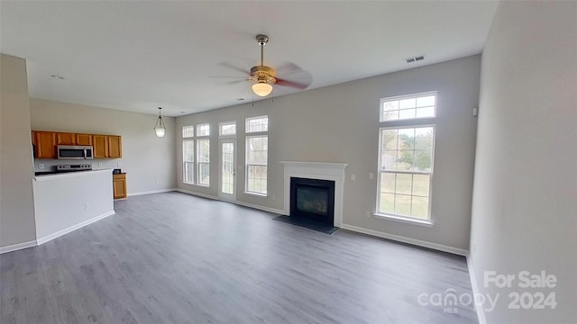 unfurnished living room featuring hardwood / wood-style flooring and ceiling fan