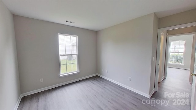 unfurnished room featuring a healthy amount of sunlight and light hardwood / wood-style flooring