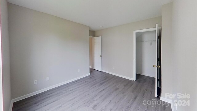 unfurnished bedroom featuring light hardwood / wood-style floors and a closet