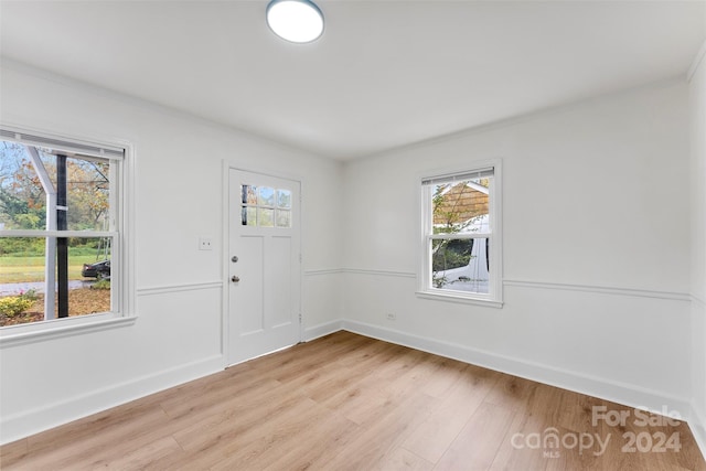 unfurnished room featuring light hardwood / wood-style floors and crown molding