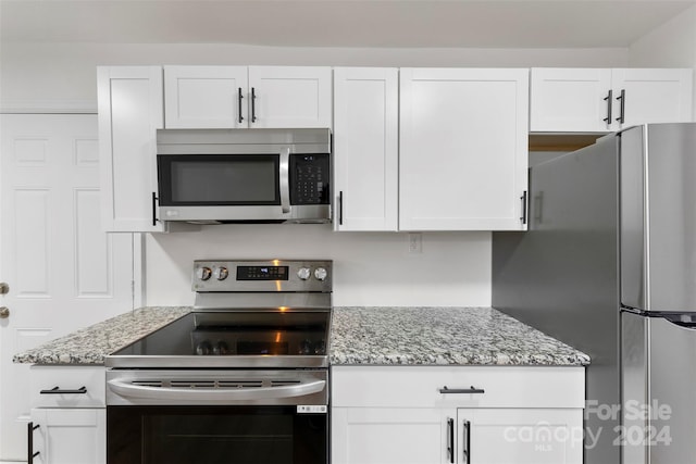 kitchen with white cabinetry, stainless steel appliances, and light stone counters