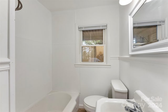 bathroom with a tub, sink, and toilet