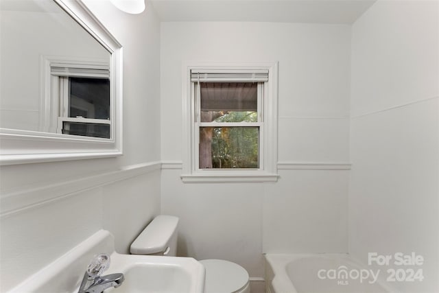 bathroom featuring sink, a bathtub, and toilet