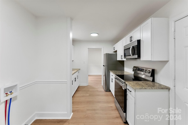 kitchen with white cabinets, light hardwood / wood-style floors, light stone countertops, and appliances with stainless steel finishes