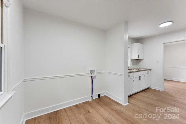 laundry room featuring light hardwood / wood-style floors, washer hookup, cabinets, and sink