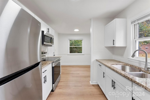 kitchen featuring a wealth of natural light, white cabinetry, appliances with stainless steel finishes, and sink