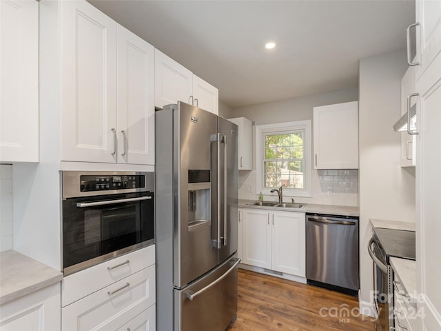 kitchen featuring sink, white cabinetry, stainless steel appliances, and light wood-type flooring