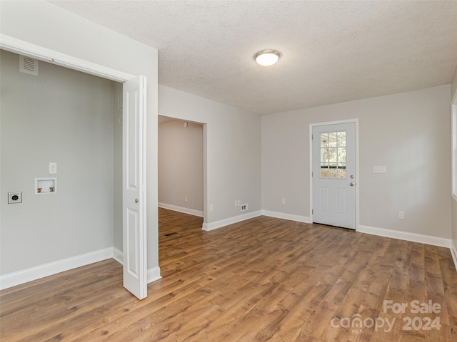 interior space featuring a textured ceiling and wood-type flooring