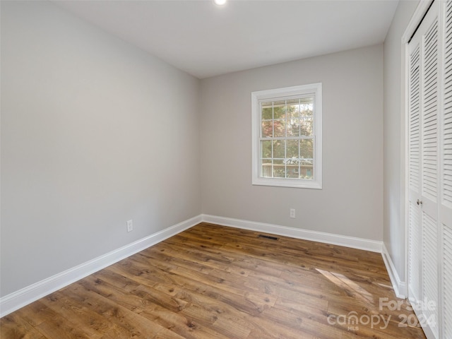 unfurnished bedroom with wood-type flooring and a closet