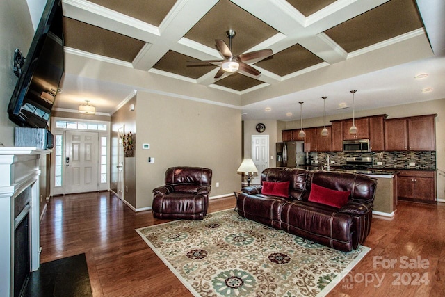 living room with dark hardwood / wood-style flooring, ceiling fan, coffered ceiling, beamed ceiling, and crown molding